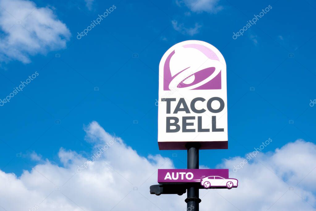 Finestrat, Spain - March 2, 2023: Taco bell logo sign on pole signboard against blue sky. Taco Bell is American-based chain of fast food restaurants, witch serve variety of Mexican-inspired foods.