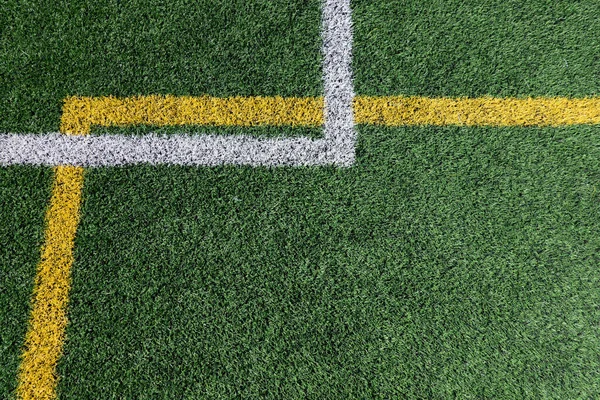绿色人造草皮足球场背景 白线和黄线边界 顶部视图 — 图库照片