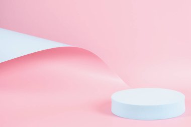 Abstract trendy composition with empty round podium platform for product or cosmetics presentation on pastel pink and light blue background. Trendy modern curved shaped lines. Front view.