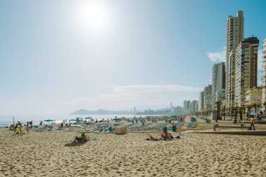 Benidorm, İspanya - 1 Nisan 2023: Yerel halk ve turistler Levante plajındaki Benidorm tatil beldesinde güneşli günün tadını çıkarıyorlar. Benidorm - Akdeniz yakınlarındaki popüler İspanyol tatil beldesi, Alicante ili, Costa Blanca