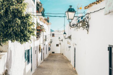 Güneşli bir günde Altea 'nın eski kasabasında beyazlatılmış evleri olan sıcacık dar bir cadde. Akdeniz yakınlarındaki küçük Altea köyünde mimarlık, Alicante vilayeti, Valensiyalı Topluluğu, İspanya.