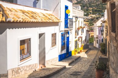 Finestrat, Alicante bölgesi, İspanya. Güneşli bir günde güzel, sessiz, sakin sokaklar, sıcacık çatıları olan eski bir kasaba manzarası..