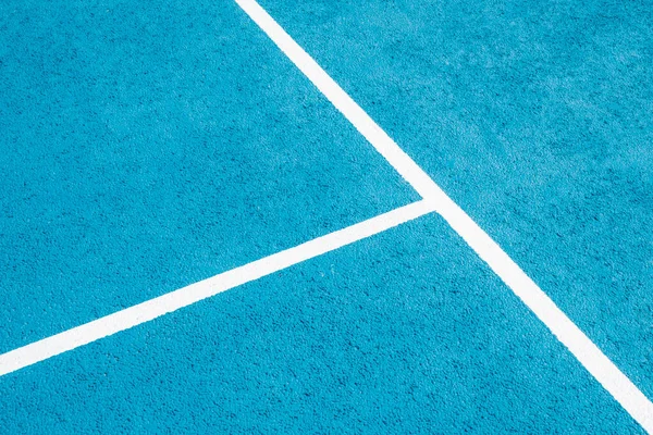 Sport field court background. Light blue rubberized and granulated ground surface with white lines. Top view.