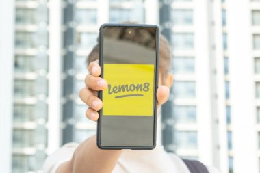 Benidorm, İspanya - Nisan 06, 2023: Genç çocuk Lemon8 uygulaması ile açık içerik paylaşım platformuna sahip telefon gösterisi. Lemon8 ByteDance 'e ait video ve fotoğraf paylaşım sosyal medya uygulaması..