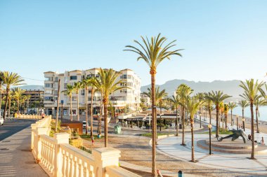 Albir, Spain - April 26, 2023: View to beautiful Albir town with main promenade, seaside beach and Mediterranean sea. Albir is small resort city between Altea and Benidorm, Alicante province, Spain. clipart
