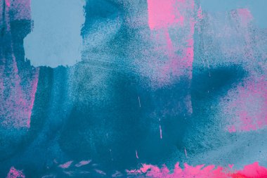 Messy paint strokes and smudges on an old painted wall background. Abstract wall surface with part of graffiti. Colorful drips, flows, streaks of paint and paint sprays.