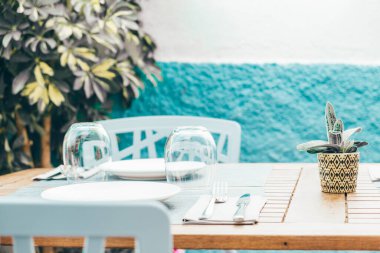 Açık teras restoranında tahta masa, güneşli bir günde yaz yemeği için kafe. İspanya 'nın samimi detayları.