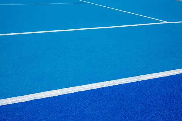 Sport field court background. Blue rubberized and granulated ground surface with white lines on ground. Top view, copy space