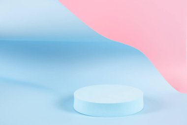 Abstract trendy composition with empty round podium platform for product or cosmetics presentation on pastel pink and light blue background. Trendy modern curved shaped lines. Front view.