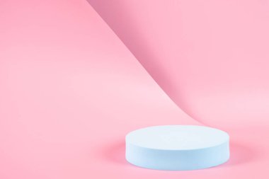 Boş mavi yuvarlak podyum platformu olan soyut moda kompozisyonu, pastel pembe arka planda ürün veya kozmetik sunumu için. Modern moda kıvrımlı hatlar. Ön görünüm.