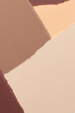 Soyut bej kahverengi renk arkaplanı. Grunge yırtık kenarlı kağıt parçaları yırttı. Üst görünüm, alanı kopyala.