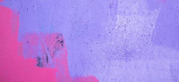 stock image Purple paint strokes and smudges on an pink painted wall background. Abstract wall surface with part of graffiti. Colorful drips, flows, streaks of paint and paint sprays.