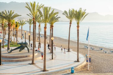 Albir, Spain - April 26, 2023: Active people exercise in the morning in Albir seaside beach promenade. Albir is stylish modern seaside resort of L Alfas del Pi, Alicante province, Spain. clipart