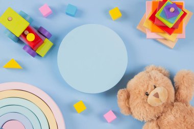 Ürün sunumu için boş bir platform platformu, oyuncak ayı ve açık mavi arka planda doğal ahşap oyuncaklar. Sürdürülebilir, bebekler için Montessori eğitim oyuncakları. Üst manzara, düz uzanma.