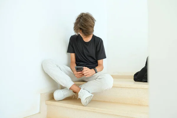 Nastolatek Siedzi Schodach Używa Smartfona Nastolatek Przeglądać Media Społecznościowe Komunikować — Zdjęcie stockowe