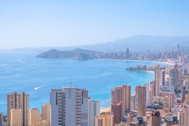 Meşhur Benidorm tatil köyünün panoraması. Akdeniz kıyıları, Benidorm gökdelenleri, oteller ve mavi gökyüzü ve arka planda dağlar. Alicante ili, İspanya.