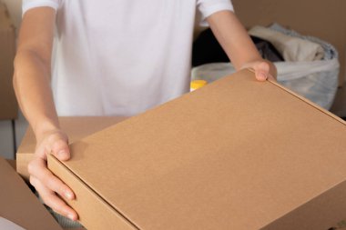 Gönüllü eller bağış için boş karton kutuyu tutuyor. Bağış, yardım, gıda bankası, düşük gelir, yoksul aileler, göçmenler, mülteciler, evsizler için yardım.