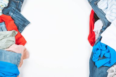 Renkli giysiler yığını. Bağış için kullanılmış kıyafetlerin soyut bir geçmişi, online satış, geri dönüşüm. Moda, ev, gardırop temizliği, dağınıklık. Üst görünüm.