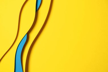Abstract colored paper texture background. Minimal paper cut composition with layers of geometric shapes and lines in light blue and yellow colors.