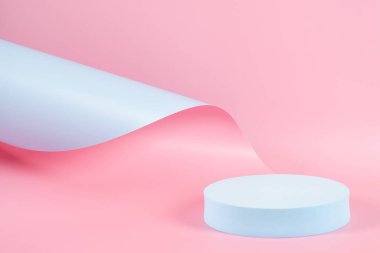 Abstract trendy composition with empty round podium platform for product or cosmetics presentation on pastel pink and light blue background. Trendy modern curved shaped lines. Front view.