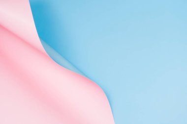 Soyut pembe ve açık mavi kağıt dalgası. Işıklı ve gölgeli yaratıcı geometrik kavisli kağıdın fotoğrafı. Kopya alanı ile soyut geometri arkaplanı.