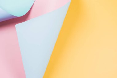 Soyut sarı dalga, pastel pembe ve açık mavi kağıt. Yaratıcı geometrik kıvrımlı, ışık ve gölgeli katı renkli kağıt. Kopya alanı ile soyut geometri arkaplanı.