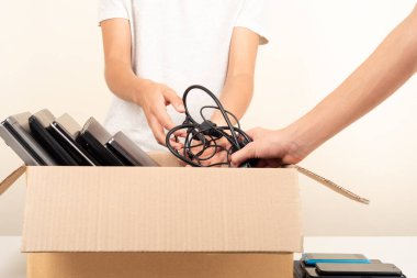 Gönüllü eller, hayır kurumlarına kullanılmış teknoloji aletleri topluyor. Eski dizüstü bilgisayarları, telefonları, tabletleri olan bağış kutusu. Teknoloji donanımı, e-atık, elektronik atık, yeniden kullanım, onarım, geri dönüşüm.