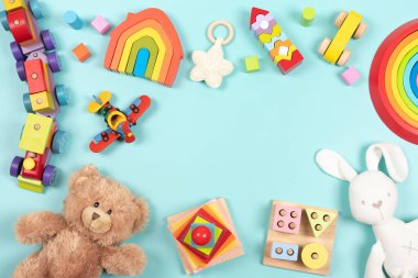 Bebek çocukların oyuncak çerçeve arka planı. Oyuncak ayı, renkli ahşap eğitim, duyusal, açık mavi arka planda çocuklar için oyuncakları ayırıp istifleme. Üst manzara, düz uzanma.