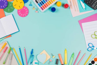 Okul geçmişine dönelim. Renkli kalemler, kalemler, kitaplar, defterler, kalemler, suluboya boya boya, makas, matematik kesirleri, pastel yeşil arka planda hesap makinesi. Üst görünüm, düz görünüm, metin için alanı kopyala.