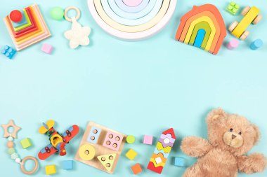 Bebek çocukların oyuncak çerçeve arka planı. Oyuncak ayı, renkli ahşap eğitim, duyusal, açık mavi arka planda çocuklar için oyuncakları ayırıp istifleme. Üst manzara, düz uzanma.