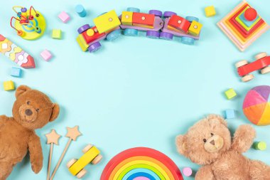 Bebek çocukların oyuncak çerçeve arka planı. Oyuncak ayılar, renkli ahşap eğitim, duyusal, açık mavi arka plandaki çocuklar için oyuncakları ayırıp istifleme. Üst manzara, düz uzanma.