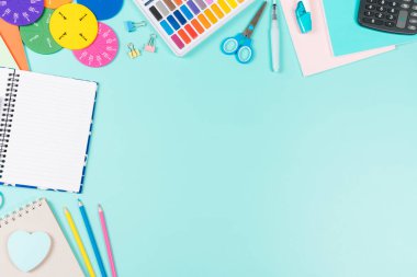 Okul geçmişine dönelim. Renkli kalemler, kitaplar, defterler, kalemler, suluboya boya, makas, matematik kesirleri, pastel yeşil arka planda hesap makinesi. Üst görünüm, düz görünüm, metin için alanı kopyala.