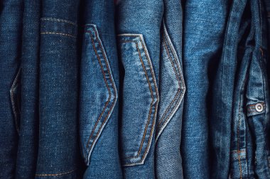 Denim geçmişi. Kot pantolon yığını. Giysilerin dikey depolanması. Üst görünüm.