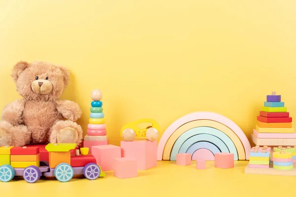 Pädagogische Sammlung Von Kinderspielzeug Teddybär Hölzerner Regenbogen Zug Stapelpyramide Rosa lizenzfreie Stockbilder