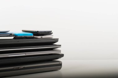 Eski dizüstü bilgisayar yığınları, dijital tabletler, beyaz masada geri dönüşüm için akıllı telefonlar. Bağış, hayır kurumlarına teknoloji, e-atık, yeniden kullanım için elektronik atık, yükseltme, onarım, geri dönüşüm konsepti.