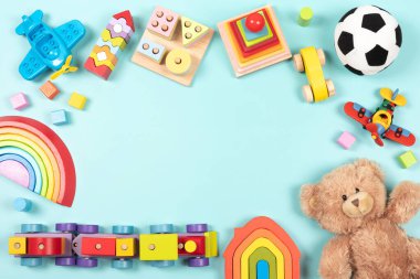 Bebek çocukların oyuncak çerçeve arka planı. Oyuncak ayı, renkli ahşap eğitim, duyusal, açık mavi arka planda çocuklar için oyuncakları ayırıp istifleme. Üst manzara, düz uzanma.