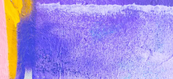 Messy paint strokes and smudges on an old painted wall. Pink, purple, white color drips, flows, streaks of paint and paint sprays on purple wall background.