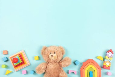 Bebek çocukların oyuncak çerçeve arka planı. Oyuncak ayı, renkli ahşap eğitim, duyusal, açık mavi arka planda çocuklar için oyuncakları ayırıp istifleme. Üst manzara, düz uzanma.