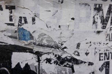 Eski grunge sökülmüş şehir sokak posterleri buruşmuş kağıt levha dokusu arka planı. Siyah duvar arka planında sökülmüş kağıt yüzey levhası.