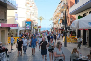 Benidorm, İspanya - 17 Mayıs 2024: Benidorm Caddesi, Akdeniz yakınlarındaki popüler İspanyol tatil beldesi. Yerel ve yabancı tatilciler Benidorm 'da güneşli bir günün tadını çıkarıyorlar.