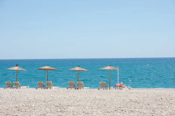 stock image View to turquoise blue Mediterranean Sea and Albir seaside beach in Alicante province, Spain. Raco de Albir Beach with white pebbles, umbrellas and beach sun loungers in beautiful sunny day.