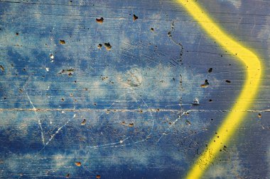Grunge weathered stucco wall with painting strokes and spray in blue and yellow colors. Part of old colorful street art graffiti.