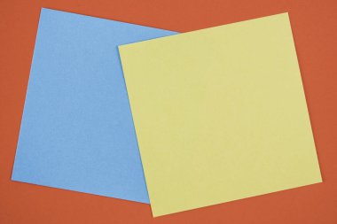 Arkaplanda boş notlar var. Kırmızı arkaplan üzerine boş sarı ve mavi notlar.