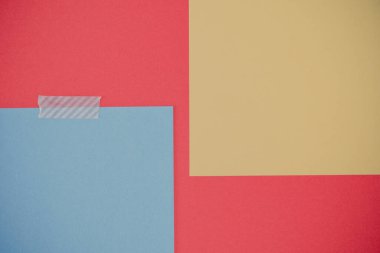 Kırmızı arka planda iki boş nota. Boş sarı ve mavi renkli notlar ve yırtık dekoratif yapışkan washi bantları..