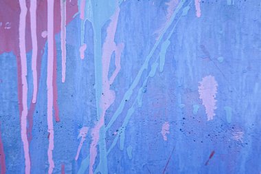 Rastgele beyaz, pembe ve mavi boya darbeleri ve damlalarıyla karışık bir duvar. Soyut eski mavi duvar dokusu.