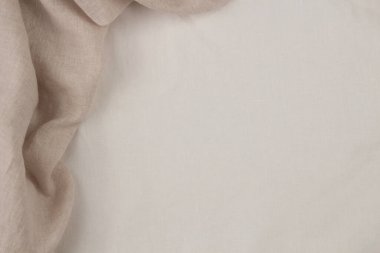 Tarafsız keten kumaş arka plan. Boş beyaz keten arka planda bej bej yumuşak katlar. Üst görünüm