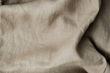 Doğal kahverengi keten kumaş kumaş dokusu arka planı. Yumuşak, buruşuk kumaş kaplama. Üst görünüm