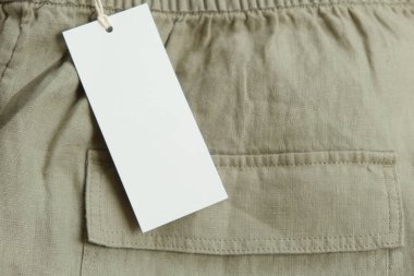 Modelleme. Beyaz etiketli keten pantolon. Marka, metin, fiyat için etiket kartı kopyalama alanı.