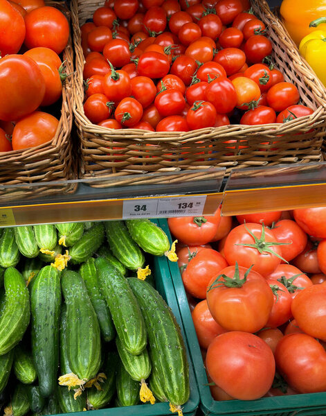 Fresh vegetables in boxes in the store. Cucumbers and tomatoes