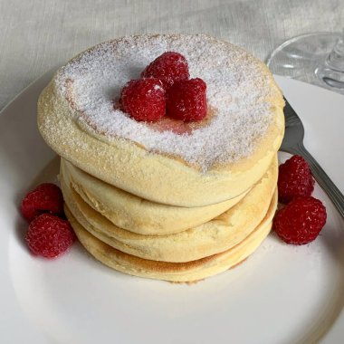 Ev yapımı Japon krepleri. Ahududu ve şeker tozuyla.